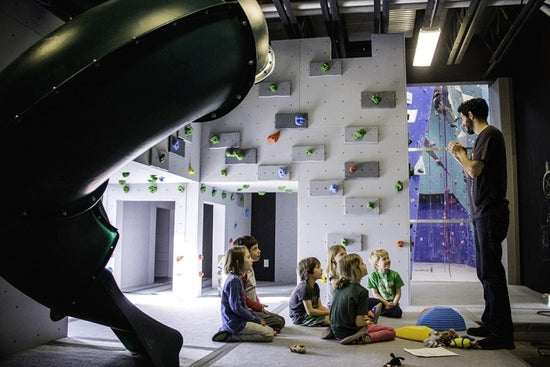 Kids sitting in the Evo Rock Gym Kids Climbing Area.